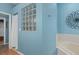 Bathroom featuring a shower, glass block window, and light blue walls at 19106 Sheldon St, Orlando, FL 32833