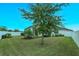 Landscaped backyard with grassy area and large tree at 2232 Donahue Dr, Ocoee, FL 34761