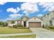 Charming one-story home with a two-car garage, landscaping, and a lush green lawn at 2232 Donahue Dr, Ocoee, FL 34761