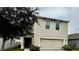 Two-story home with beige siding and two-car garage at 3033 Timber Hawk Cir, Ocoee, FL 34761