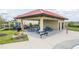 Neighborhood pavilion featuring picnic tables, seating, and a playground in a fenced area at 351 Lazio Cir, Debary, FL 32713