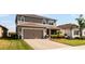 Two-story house with a two-car garage, landscaping, and palm trees at 351 Lazio Cir, Debary, FL 32713