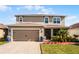 Two-story house with a two-car garage and landscaped front yard at 351 Lazio Cir, Debary, FL 32713