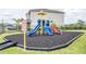 Community playground featuring slides, climbing structures, and a safety sign on a mulch base at 351 Lazio Cir, Debary, FL 32713