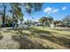 Large backyard showcasing a home with palm trees and lush landscaping at 5703 Se 109Th St, Belleview, FL 34420