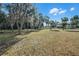 Spacious backyard with mature trees and a large grassy area at 5703 Se 109Th St, Belleview, FL 34420