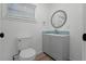 Updated bathroom with gray vanity and a unique circular mirror at 5703 Se 109Th St, Belleview, FL 34420