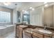Elegant bathroom with double sinks, granite countertops, and a soaking tub at 675 Overspin Dr, Winter Park, FL 32789