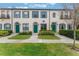 Three-unit townhouse building with green doors and landscaping at 711 Centervale Dr # 711, Celebration, FL 34747