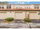 Three-car garage with tan stucco exterior and landscaping at 711 Centervale Dr # 711, Celebration, FL 34747