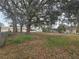 Fenced backyard featuring mature trees and partial views of the home and pool at 770 Mink Ct, Poinciana, FL 34759