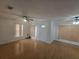 Open-concept living room with hardwood floors, neutral walls, natural light from vertical blinds, and ceiling fans at 770 Mink Ct, Poinciana, FL 34759