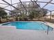 Enclosed pool area featuring a sparkling in-ground pool with a screened enclosure and a spacious patio deck at 770 Mink Ct, Poinciana, FL 34759