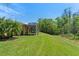 An expansive backyard featuring a screened lanai, lush green grass and mature landscaping at 800 Ebb Tide Ln, Kissimmee, FL 34759