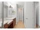 Bathroom with double sinks, wooden cabinets, and view into the hallway with tile floor at 800 Ebb Tide Ln, Kissimmee, FL 34759