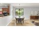 Bright dining room with a modern chandelier and a view of the landscaped backyard through a large window at 800 Ebb Tide Ln, Kissimmee, FL 34759