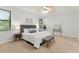 A bright, carpeted primary bedroom featuring a tufted headboard and a ceiling fan with light fixture at 800 Ebb Tide Ln, Kissimmee, FL 34759