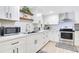 White kitchen features stainless steel appliances and wood floating shelves at 805 Wingo St, Orlando, FL 32803