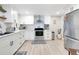 Modern white kitchen with stainless steel appliances and light wood flooring at 805 Wingo St, Orlando, FL 32803