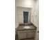 Bathroom with a granite vanity top, white cabinets, a large frameless mirror, and modern fixtures at 9088 Ocean Tide Way, Kissimmee, FL 34747