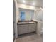 Bathroom features a double sink vanity with granite countertop, white cabinets and a large mirror at 9088 Ocean Tide Way, Kissimmee, FL 34747