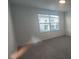 A carpeted bedroom featuring a window with blinds, providing a view of the exterior and natural light at 9088 Ocean Tide Way, Kissimmee, FL 34747