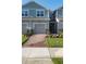 Inviting townhouse exterior with a well-maintained lawn and a brick pathway leading to the front entrance at 9088 Ocean Tide Way, Kissimmee, FL 34747