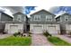 Charming townhouse featuring a well-manicured front lawn and inviting brick pathway leading to the front door at 9088 Ocean Tide Way, Kissimmee, FL 34747