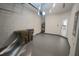 A well-lit garage with white block walls, featuring a gray epoxy floor and an entry door to the home at 9088 Ocean Tide Way, Kissimmee, FL 34747