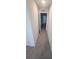 Neutral-toned hallway with carpet flooring and white-painted walls featuring open doors to additional rooms in the home at 9088 Ocean Tide Way, Kissimmee, FL 34747