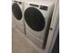 A modern laundry room with a side-by-side, front-loading washer and dryer at 9088 Ocean Tide Way, Kissimmee, FL 34747
