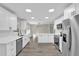 Open concept kitchen with white cabinets and stainless steel appliances at 10842 Sw 67Th Ave, Ocala, FL 34476