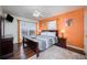 Bedroom with wood floors, orange accent wall, and a king-size bed at 111 Vista Dr, Davenport, FL 33897