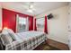 Bedroom with red accent wall, wood floors, and a double bed at 111 Vista Dr, Davenport, FL 33897