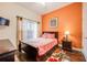 Bright bedroom with wood floors, orange accent wall, and a double bed at 111 Vista Dr, Davenport, FL 33897