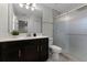 Clean bathroom with dark vanity and a glass shower door at 11868 Pulitzer Pl, Orlando, FL 32832