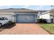 Two-car garage with brick paver driveway and landscape at 11868 Pulitzer Pl, Orlando, FL 32832