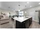 Open concept kitchen with island, dark cabinetry, and view to living room at 11868 Pulitzer Pl, Orlando, FL 32832
