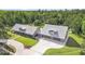 A sprawling home featuring a metal roof, lush landscaping and an expansive concrete driveway at 12788 Gillard Rd, Winter Garden, FL 34787