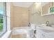 Bathroom featuring tiled walls, a window, a shower-tub combo, and a single sink vanity at 12788 Gillard Rd, Winter Garden, FL 34787