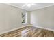 Cozy bedroom with wood floors, neutral walls, and a view of the front yard at 12788 Gillard Rd, Winter Garden, FL 34787