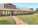 A charming brick home with a light-colored metal roof, brick pathway, shutters and front garden at 12788 Gillard Rd, Winter Garden, FL 34787