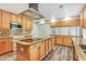 Spacious kitchen with a large island, wood cabinets, granite countertops, and modern appliances at 12788 Gillard Rd, Winter Garden, FL 34787