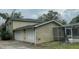 Back of house showing a two-car garage and screened pool area at 1450 Warrior Trl, Deltona, FL 32725