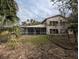 Two-story house exterior with stone and stucco siding, screened porch, and surrounding trees at 1450 Warrior Trl, Deltona, FL 32725