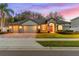 Two-story house with a three-car garage and landscaped yard at 15336 Firelight Dr, Winter Garden, FL 34787