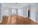 Open-concept living room with wood flooring, arched entryways, and a white front door at 15336 Firelight Dr, Winter Garden, FL 34787