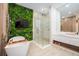 Modern bathroom with a soaking tub, glass shower, and a unique vertical garden at 16106 Pendio Dr, Bella Collina, FL 34756