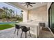 Modern outdoor kitchen with built-in grill and bar seating at 16106 Pendio Dr, Bella Collina, FL 34756