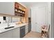 Modern wet bar with a sink, dishwasher, and ample storage at 16106 Pendio Dr, Bella Collina, FL 34756